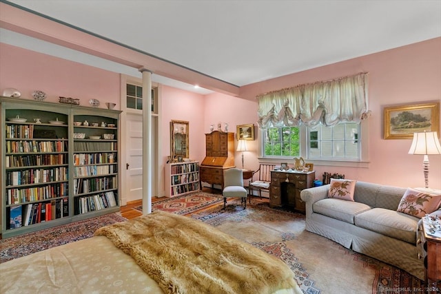 living room featuring hardwood / wood-style floors, a baseboard heating unit, and decorative columns