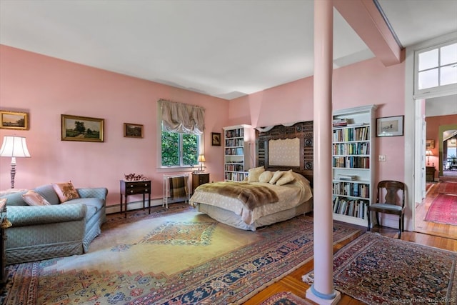 bedroom with dark hardwood / wood-style floors and a baseboard radiator