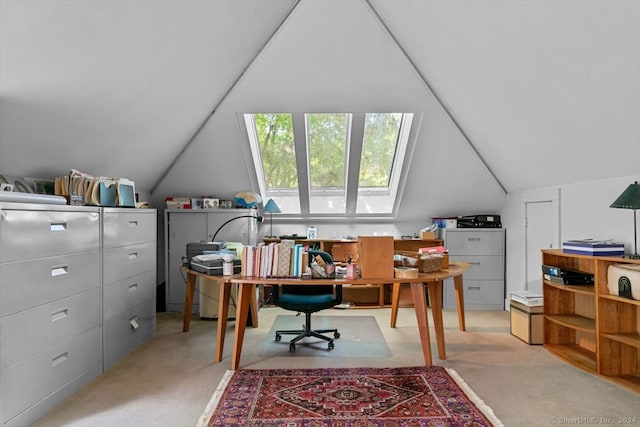 home office featuring vaulted ceiling with skylight and light colored carpet