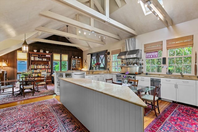 kitchen with beam ceiling, white cabinetry, and a wealth of natural light