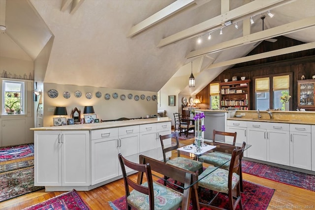 kitchen with lofted ceiling with beams, sink, white cabinets, and decorative light fixtures