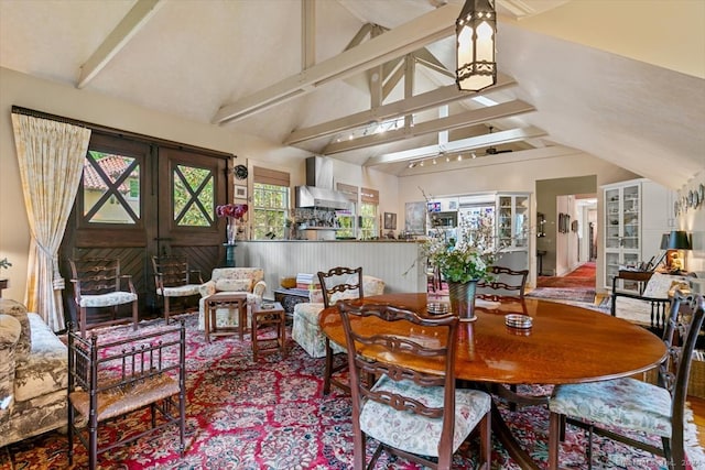 dining space with wood-type flooring and lofted ceiling with beams