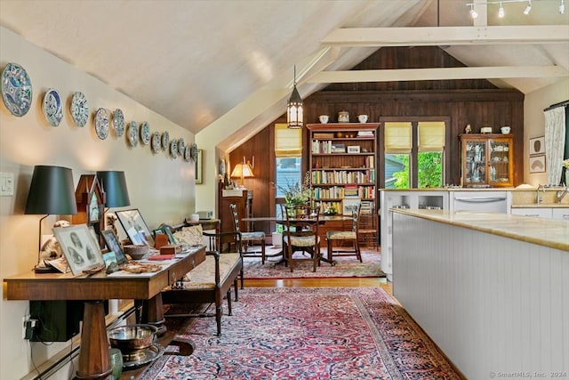 office area featuring wood walls, vaulted ceiling with beams, wood-type flooring, and track lighting