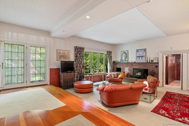 living room featuring light wood-type flooring, a brick fireplace, and a healthy amount of sunlight