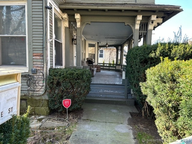 view of exterior entry featuring covered porch