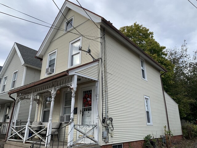 view of front of property with a porch and cooling unit