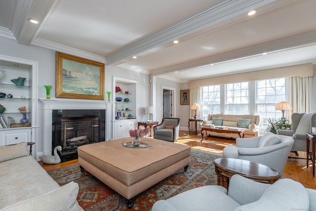 living room with ornamental molding, wood-type flooring, beamed ceiling, and built in features