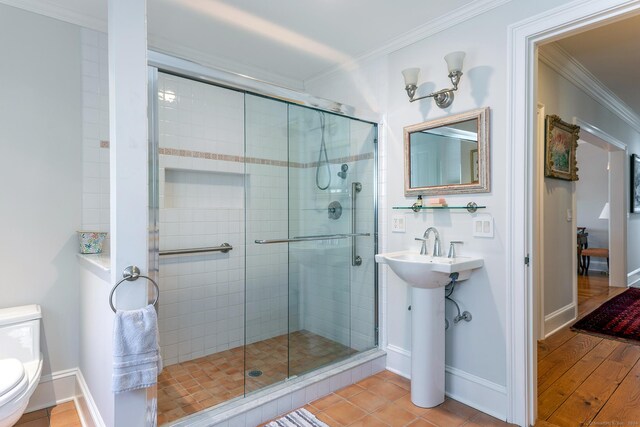 bathroom featuring ornamental molding, walk in shower, hardwood / wood-style flooring, and toilet