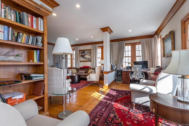 living room with ornate columns, light wood-type flooring, and ornamental molding