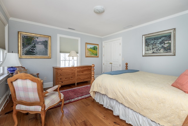 bedroom featuring ornamental molding, a closet, and hardwood / wood-style floors