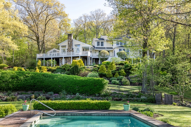 rear view of property with a fenced in pool