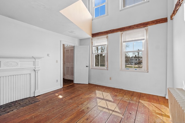 empty room featuring radiator heating unit and dark wood-type flooring