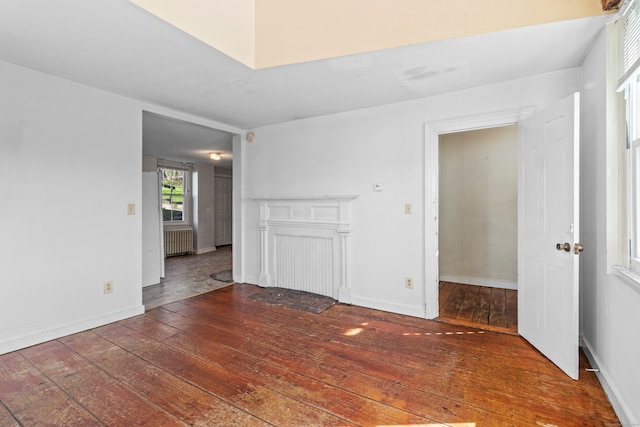 spare room with dark tile floors and radiator heating unit