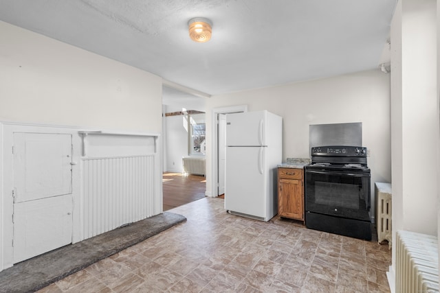 kitchen featuring white refrigerator, black range with electric cooktop, radiator heating unit, and light tile floors