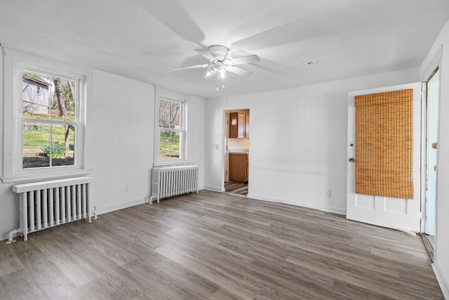 interior space featuring radiator, dark wood-type flooring, and ceiling fan