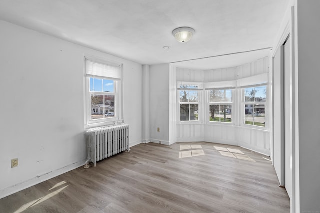 spare room featuring light hardwood / wood-style floors and radiator heating unit