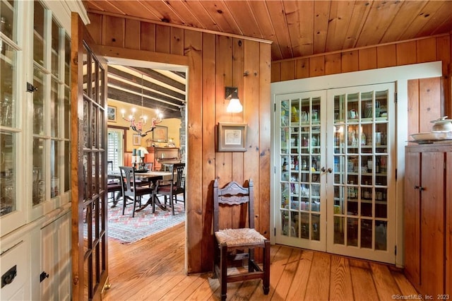 entryway with wood ceiling, french doors, a chandelier, and light hardwood / wood-style flooring