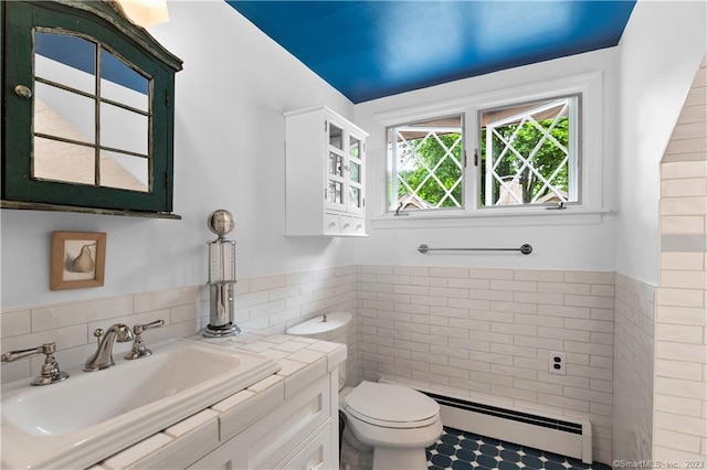 bathroom featuring vanity, a baseboard radiator, tile walls, and toilet