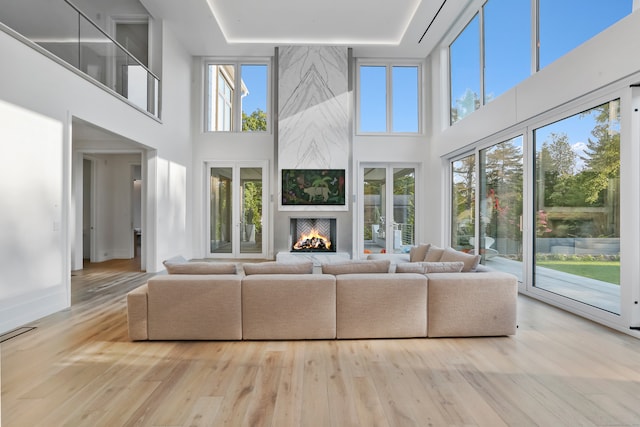 83 Red Coat Rd, Westport, CT 06880 - unfurnished living room featuring a healthy amount of sunlight, light hardwood / wood-style flooring, and a large fireplace