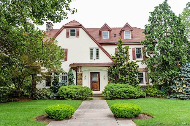 tudor-style house with a front yard