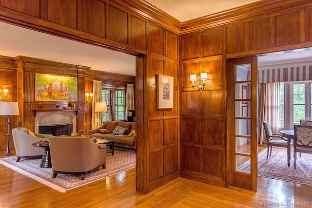 interior space featuring ornamental molding, wood walls, and light wood-type flooring