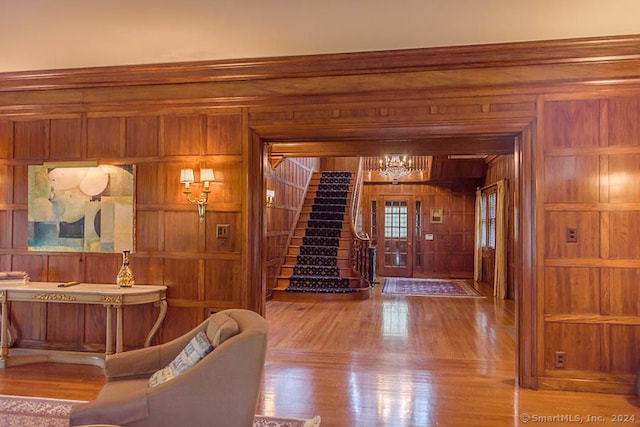 foyer entrance featuring wood walls and light hardwood / wood-style flooring