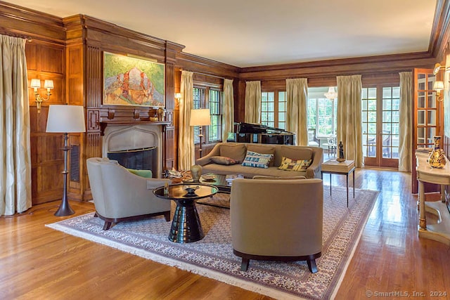 living room with light hardwood / wood-style floors, french doors, and ornamental molding