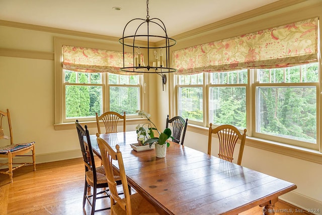 dining room featuring crown molding, an inviting chandelier, and light hardwood / wood-style floors