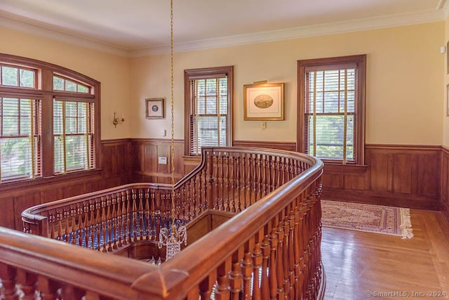 corridor with a chandelier, hardwood / wood-style flooring, and crown molding