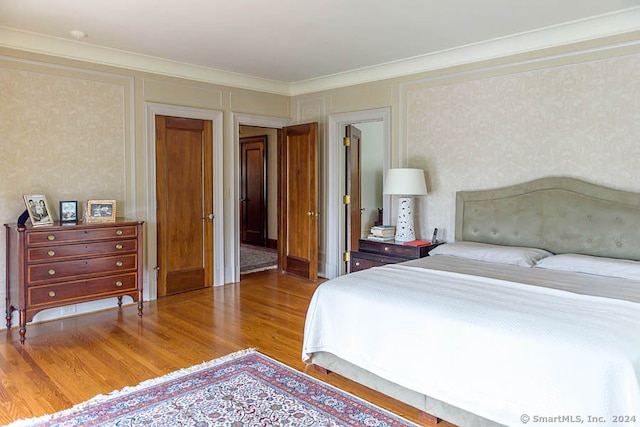 bedroom featuring hardwood / wood-style flooring and ornamental molding