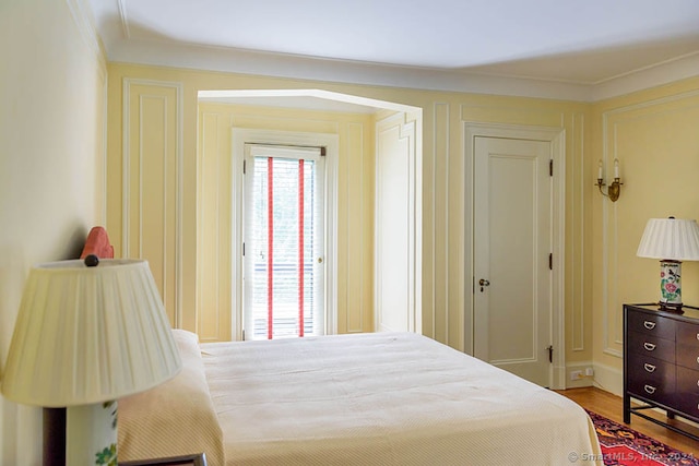 bedroom featuring ornamental molding and light wood-type flooring