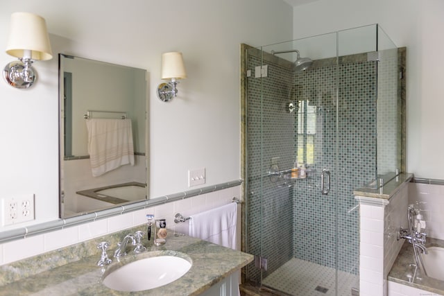 bathroom with vanity, backsplash, and a shower with shower door