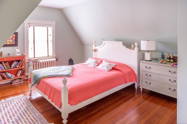 bedroom featuring dark hardwood / wood-style flooring, vaulted ceiling, and radiator heating unit