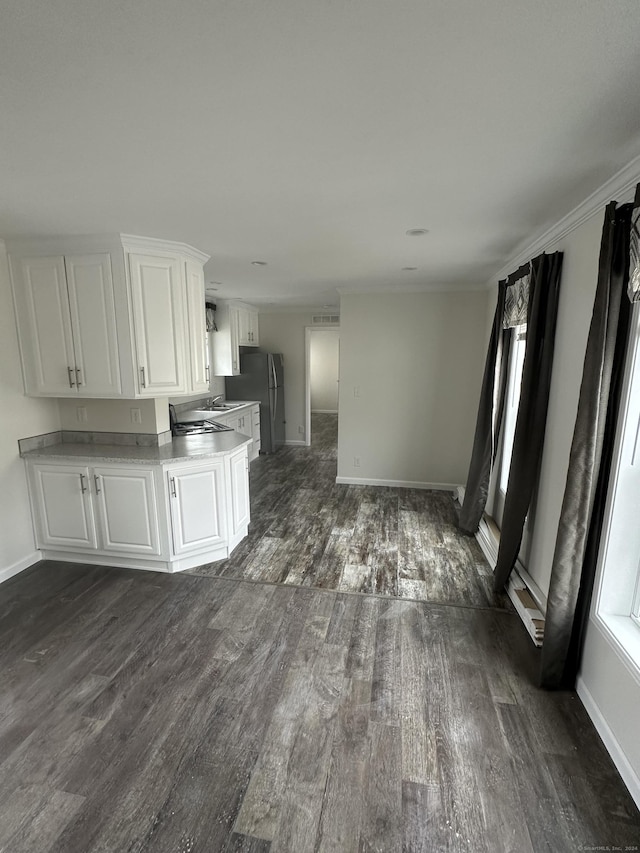 kitchen featuring crown molding, white cabinetry, stainless steel fridge, and dark hardwood / wood-style flooring