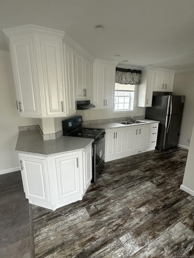 kitchen featuring black range with electric stovetop, white cabinetry, and refrigerator