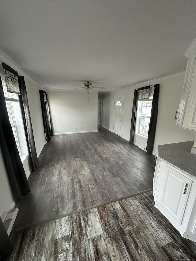 unfurnished living room with ornamental molding, ceiling fan, and dark hardwood / wood-style flooring