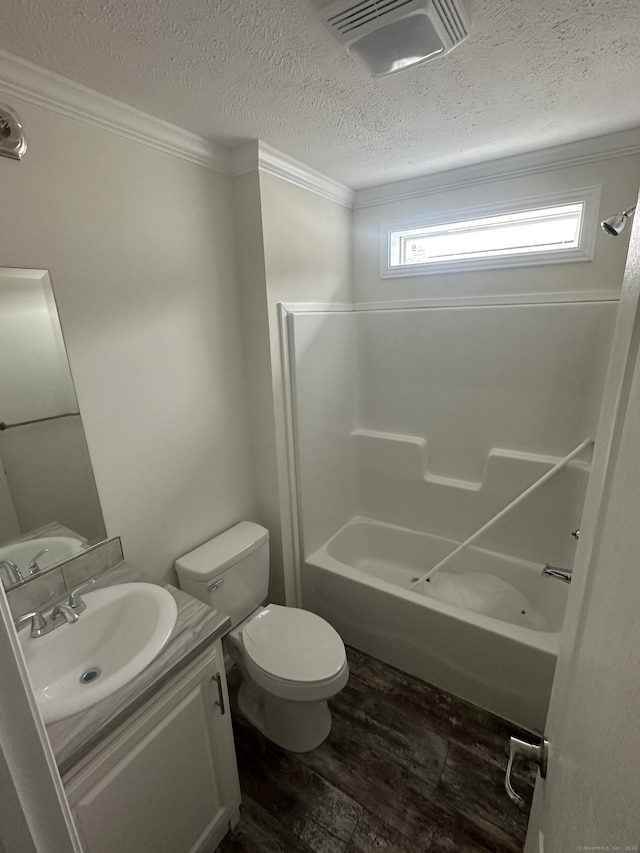 full bathroom featuring hardwood / wood-style floors, vanity, toilet, ornamental molding, and shower / bathtub combination