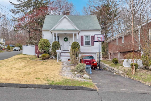 bungalow with a garage and a front lawn