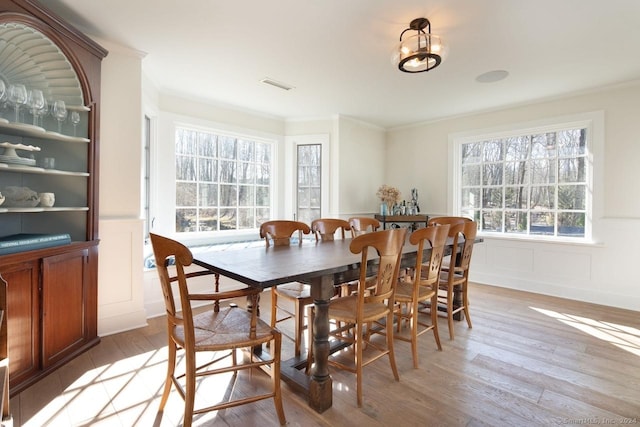 dining area featuring crown molding and light hardwood / wood-style floors