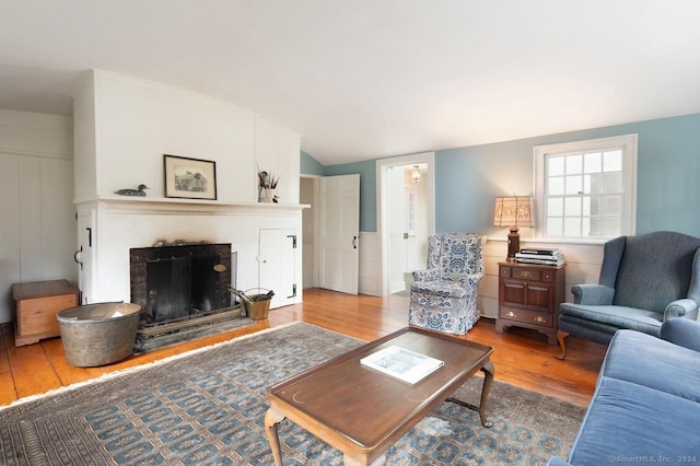living room featuring light hardwood / wood-style floors and vaulted ceiling