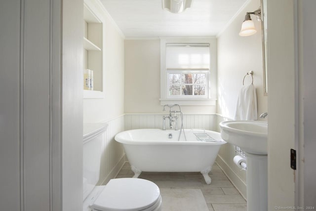 bathroom featuring a washtub, ornamental molding, and toilet