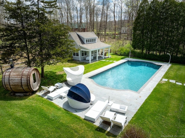 view of swimming pool featuring a patio area, an outdoor structure, and a lawn