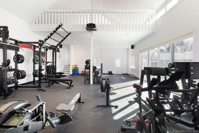 exercise room featuring a towering ceiling