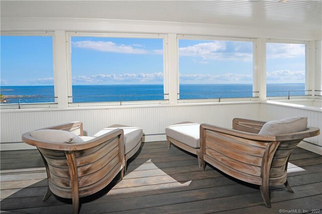 sunroom / solarium with a water view and radiator