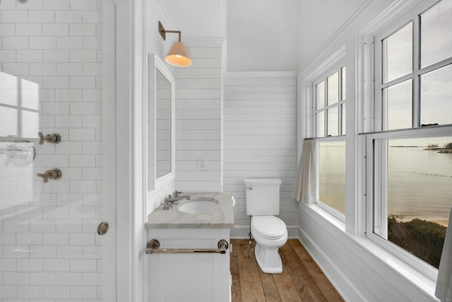 bathroom with hardwood / wood-style flooring, vanity, crown molding, and toilet