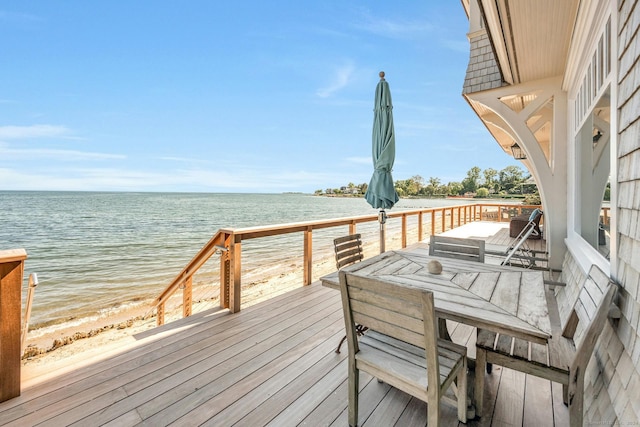 wooden deck with a beach view and a water view