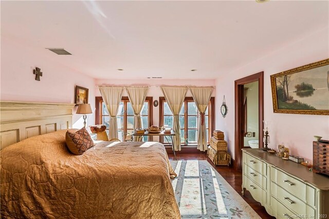 bedroom with french doors and dark hardwood / wood-style flooring