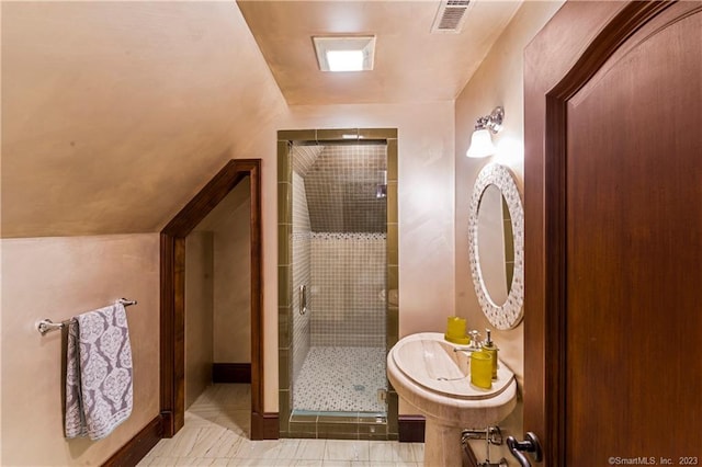 bathroom featuring tile patterned floors, vaulted ceiling, and a shower with shower door