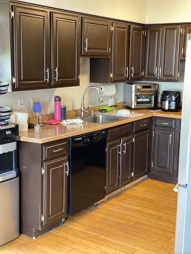 kitchen with dark brown cabinetry, light wood-type flooring, and black dishwasher