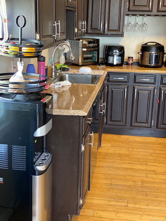 kitchen with light hardwood / wood-style flooring, sink, and dark brown cabinets